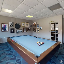 a room with a pool table and art on the walls