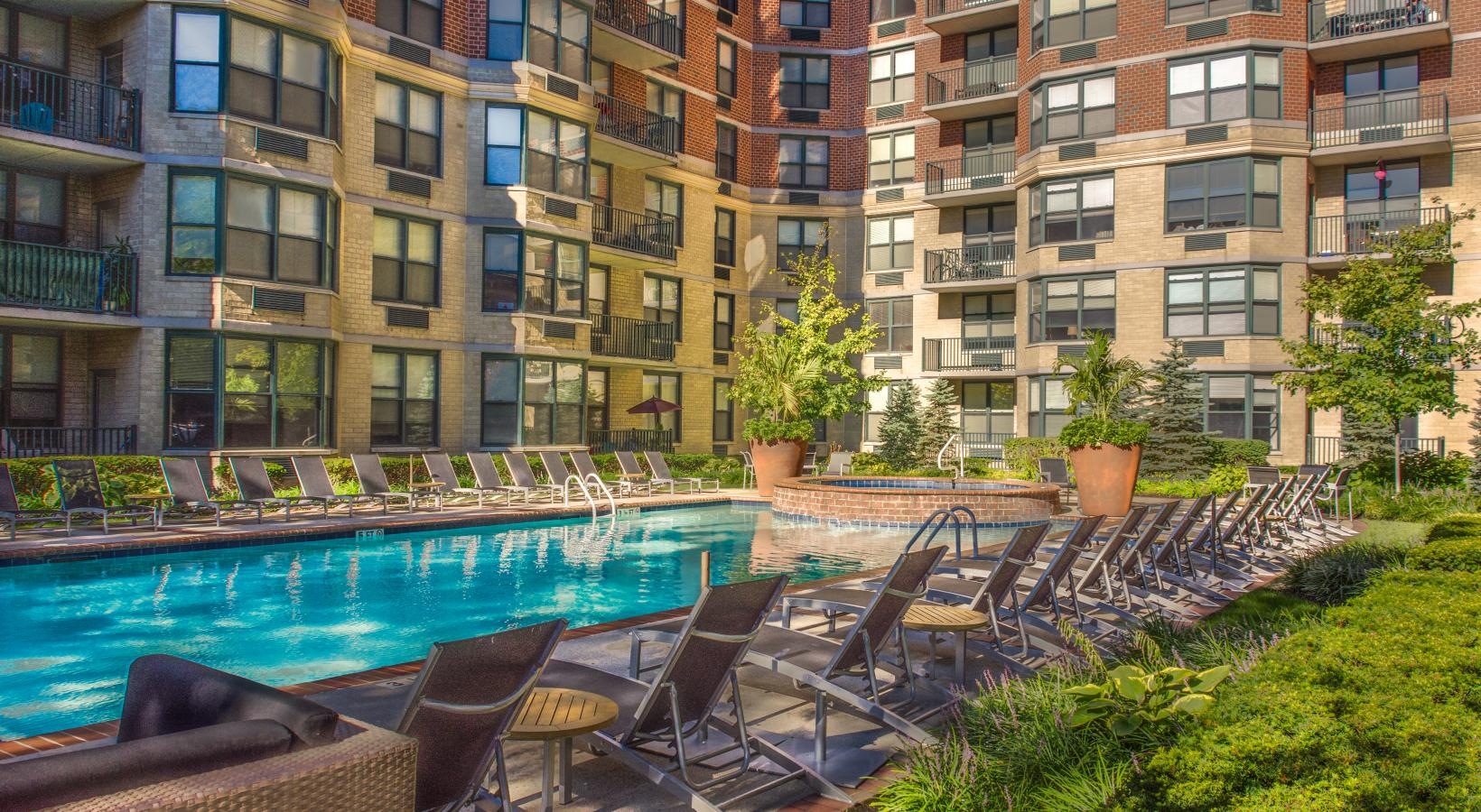 Relax and unwind poolside a pool with chairs around it