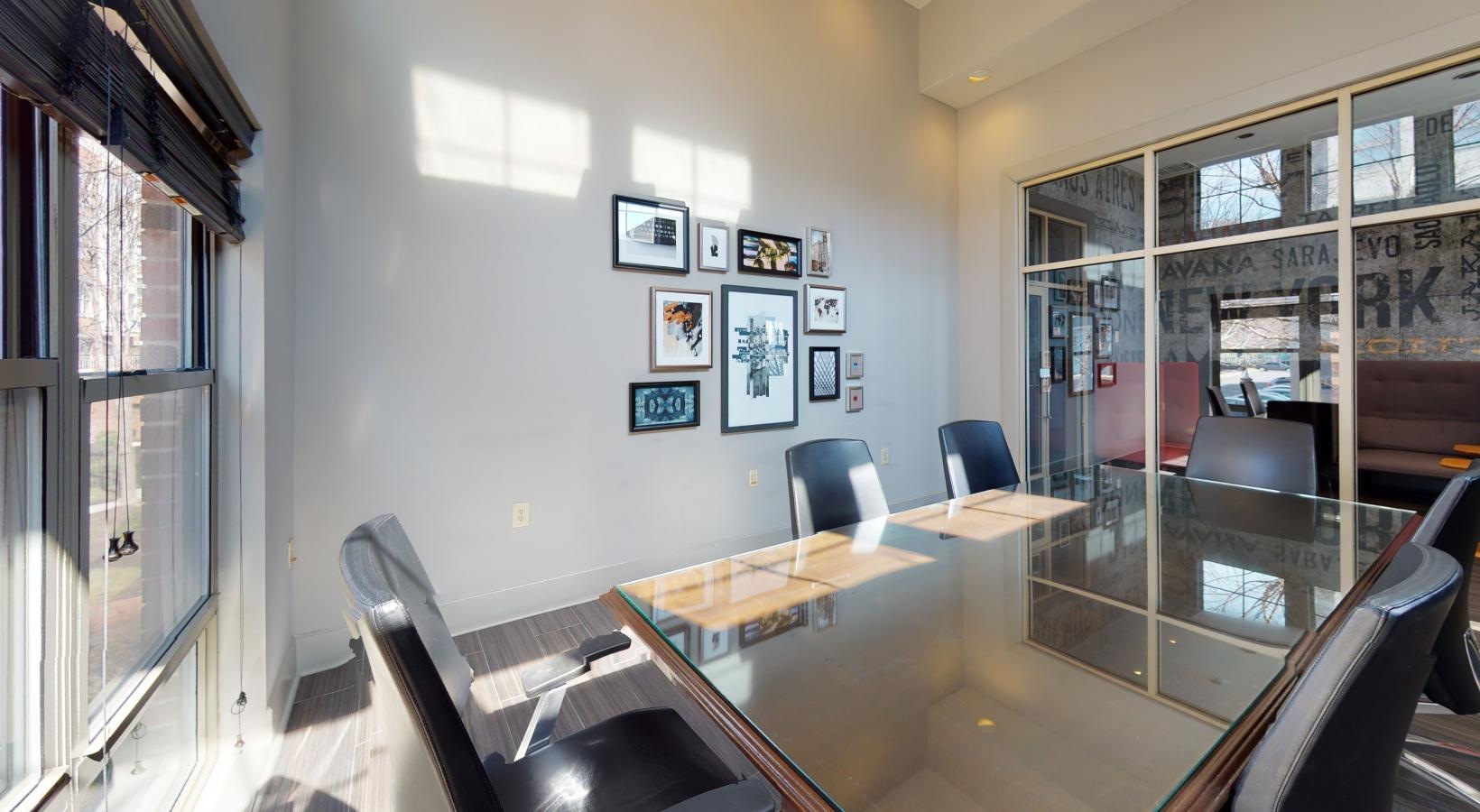 Settle into comfort at Riverbend at Port Imperial a room with a table chairs and a glass door